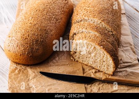 Geschnittenes graues Brot auf Pergamentpapier Stockfoto