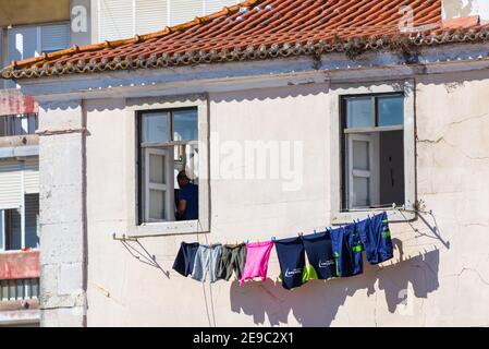 Portugal, Lissabon, 09. Oktober 2018: Leinen hängt an einer Straße in Lissabon, Portugal. Architektur mit Kleidung, die zum Trocknen aus dem Fenster hängt. Stockfoto