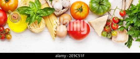 Nudeln, Tomaten und Kräuter. Kochzutaten auf Holztisch. Draufsicht flach liegend Stockfoto