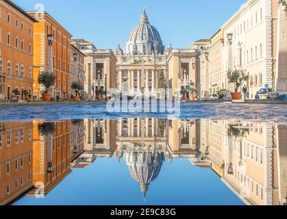 Häufige Regenschauer schaffen Pools, in denen sich die wunderbare Altstadt Roms wie in einem Spiegel spiegelt. Hier insbesondere der Petersdom Stockfoto