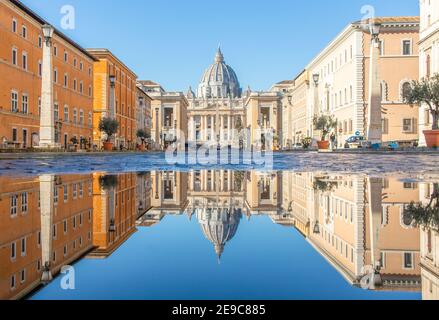 Häufige Regenschauer schaffen Pools, in denen sich die wunderbare Altstadt Roms wie in einem Spiegel spiegelt. Hier insbesondere der Petersdom Stockfoto