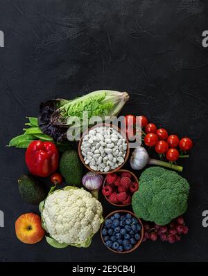 Gesunde Ernährung Hintergrund, trendige pflanzliche Ernährung Produkte - frisches rohes Gemüse, Beeren und Bohnen. Stockfoto