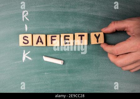 Risiko- und Sicherheitskonzept. Der Text aus den Buchstaben des hölzernen Alphabets auf dem grünen Kreidetafel. Stockfoto