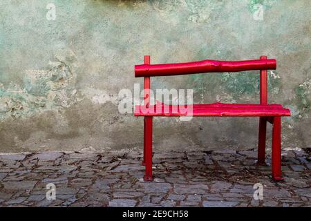 Eine schöne und ruhige Ecke mit einer roten Holzbank, Stockfoto