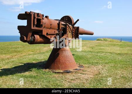 Das alte rostige Marinegewehr zeigt auf das Meer. Stockfoto