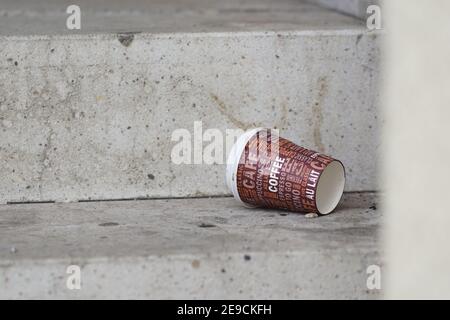 Einweg-Kaffee zu CO Tasse auf dem Boden weggeworfen - Abfall und Umweltverschmutzung Stockfoto