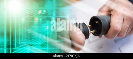 Elektroinstallateur hält Elektrostecker in der Hand; Mehrfachbelastung Stockfoto