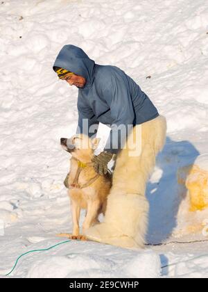 Die Schlittenhunde zu spannen. Der Jäger trägt traditionelle Hosen und Stiefel aus Eisbärpelz. Die traditionelle und abgelegene grönländische inuit Stockfoto