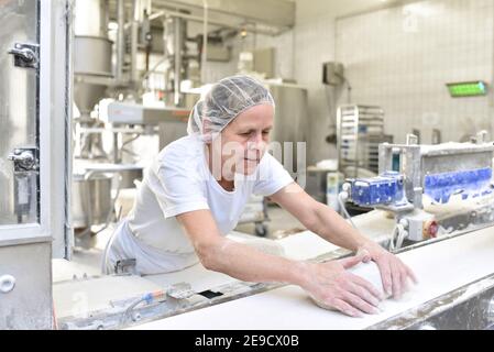 Arbeiter in einer Großbäckerei - Industrieproduktion von Backwaren auf einer Fließstrecke Stockfoto