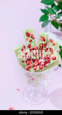 Fudge, süße Bonbons, handgemachtes Dessert aus weißer Schokolade, Matcha-Tee und Erdbeeren auf hellem Hintergrund. Selektiver Fokus, Kopierbereich Stockfoto