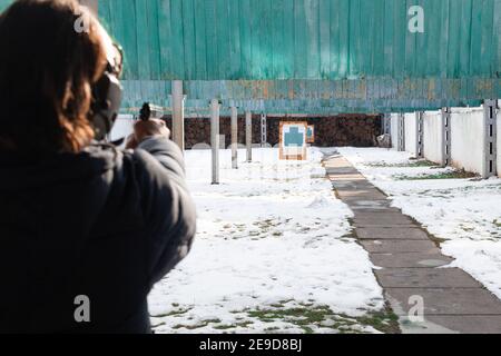 Ein Mann schießt ein Ziel in einem Schlag. Wintersport, Unterhaltung, Schusswaffen, Pistole. Stockfoto