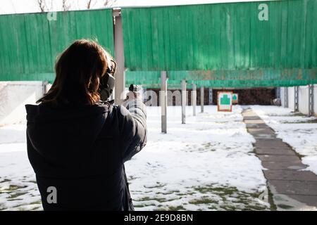 Ein Mann schießt ein Ziel in einem Schlag. Wintersport, Unterhaltung, Schusswaffen, Pistole. Stockfoto