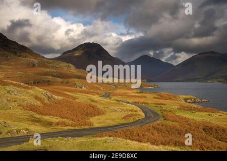 Blick auf Wastwater im Lake District an einem bewölkten Herbstnachmittag mit einspuriger Straße durch die Landschaft. Stockfoto