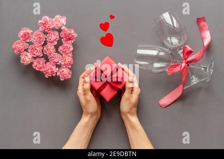 Rote Geschenkbox in Frauenhand - Valentinstag Feier. Draufsicht Stockfoto