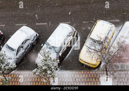 Blick von oben auf drei Autos auf der Straße geparkt Und mit Schnee bedeckt Stockfoto