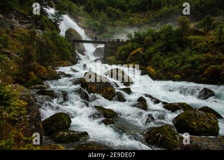 Briksdalselva Fluss, mit Kleivafossen Wasserfall im Hintergrund, direkt unter dem Briksdalbreen, Briksdal Gletscher, Norwegen. Stockfoto