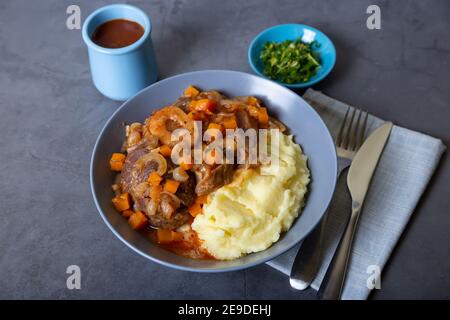 Ossobuco. Kalbsbretter mit Kartoffelpüree, Gremolata und Sauce. Traditionelles italienisches Gericht. Nahaufnahme. Stockfoto