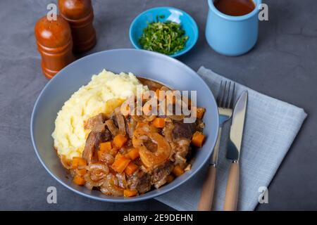 Ossobuco. Kalbsbretter mit Kartoffelpüree, Gremolata und Sauce. Traditionelles italienisches Gericht. Nahaufnahme. Stockfoto