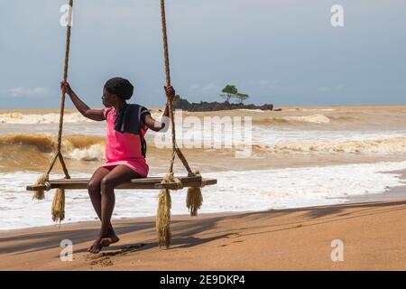 Afrikanische Frau sitzt am Meer auf einem Hängesessel. Axim Ghana West Africa Beach 2018 November 2 Stockfoto