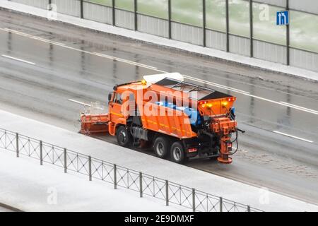 Schneepflug Gritter fährt auf der Seite einer Straße Bedeckt mit einer dünnen Eisschicht Stockfoto