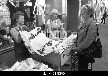 15. Oktober 1984, Sachsen, Eilenburg: HO Textilwaren Verkaufsfrauen verkaufen im Herbst 1984 in Eilenburg Tischdecken und Wischtücher vor ihrem Laden. Das genaue Datum des Fotos ist nicht bekannt. Foto: Volkmar Heinz/dpa-Zentralbild/ZB Stockfoto