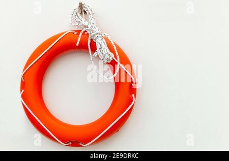 Rote Rettungsring mit Seil hängen an der weißen Wand. Sicherheitsausstattung im Schwimmbereich Stockfoto