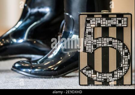 London, Großbritannien. Februar 2021, 4th. Designer Wellington Stiefel von Chanel mit Camellia Design (Teil eines Sets von 2 Paaren) est £200-300 mit einem Schwarz-Gold No,5 Plexiglas Miniauiere, Chanel, Limited Edition Herbst 2015, est £4.000 - 6.000 - Preview of Bonhams' The Chanel Collection: Online-Auktion für das französische Luxusmodehaus und bietet mehr als 200 Stücke von Kleidung und Accessoires bis hin zu Handtaschen und Schmuck bei Bonhams Knightsbridge. Der Verkauf wird eine zeitlich festgelegte Online-Auktion sein, die vom 5. Bis einschließlich 16. Februar 11 Tage lang läuft. Kredit: Guy Bell/Alamy Live Nachrichten Stockfoto