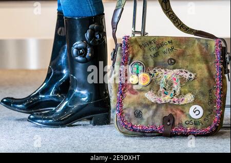 London, Großbritannien. Februar 2021, 4. Designer Wellington Stiefel von Chanel mit Camellia Design (Teil eines Sets von 2 Paaren) est £200-300 mit einem Graffiti auf dem Bürgersteig Messenger Bag, Frühjahr 2015, Graffiti Design khaki Canvas mit gesticktem CC Design und Pin Abzeichen, brauner Lederbesatz. Taxe £1.500-2.000 - Vorschau auf Bonhams' The Chanel Collection: Online-Auktion für das französische Luxusmodehaus mit mehr als 200 Kleidungsstücken, Accessoires, Handtaschen und Schmuck in Bonhams Knightsbridge. Der Verkauf wird eine zeitlich begrenzte Online-Auktion läuft für 11 Tage von 5 bis 16 F Stockfoto