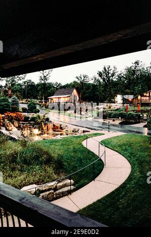 Ein luxuriöses Resort mit klassischen Holzhäusern und künstlichen Wasserfälle im Sommer Stockfoto