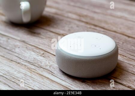 Ein Amazon Echo Punkt oder amazon Alexa Gerät isoliert auf Ein Holztisch oder Schreibtisch Stockfoto