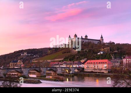 Blick auf Festung Marienberg und Alte Mainbrücke, Alte Mainbrücke in Würzburg bei rosa Sonnenuntergang, Bayern, Deutschland Stockfoto