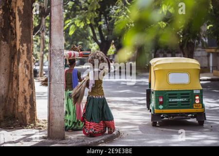 Bengaluru, Indien - 08. Juni 2020. Indische Frauen in bunten Sarees tragen ein Bündel auf dem Kopf. Indien, Bengaluru Stockfoto