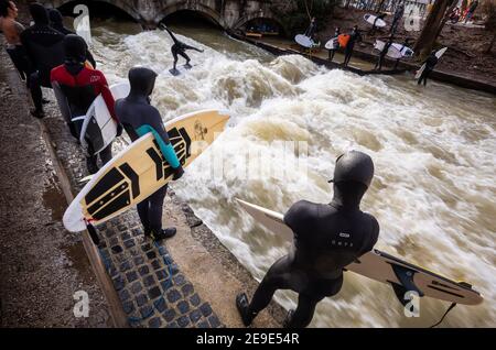 München, Deutschland. Februar 2021, 04th. Die Eisbachwelle in der Nähe der Prinzregentenstraße am Rande des Englischen Gartens ist gut besucht. Der Freizeit-Hotspot ist das ganze Jahr über ein Magnet für Surfer. Kredit: Peter Kneffel/dpa/Alamy Live Nachrichten Stockfoto