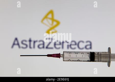 OXFORD, Großbritannien - Februar 2020: Covid-Impfstoffspritze vor dem AstraZeneca-Logo Stockfoto
