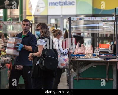BELGRAD, SERBIEN - 10. OKTOBER 2020: Frau mittleren Alters, die in Zeleni Venac Lebensmittel kauft und läuft Belgrader grüner Bauernmarkt trägt Gesichtsmaske e Stockfoto