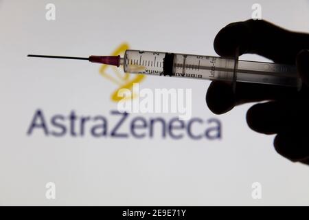 OXFORD, Großbritannien - Februar 2020: Covid-Impfstoffspritze vor dem AstraZeneca-Logo Stockfoto