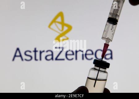 OXFORD, Großbritannien - Februar 2020: Covid-Impfstoffspritze vor dem AstraZeneca-Logo Stockfoto