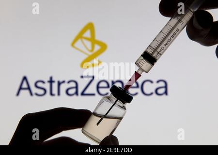 OXFORD, Großbritannien - Februar 2020: Covid-Impfstoffspritze vor dem AstraZeneca-Logo Stockfoto