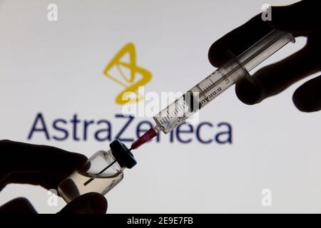 OXFORD, Großbritannien - Februar 2020: Covid-Impfstoffspritze vor dem AstraZeneca-Logo Stockfoto