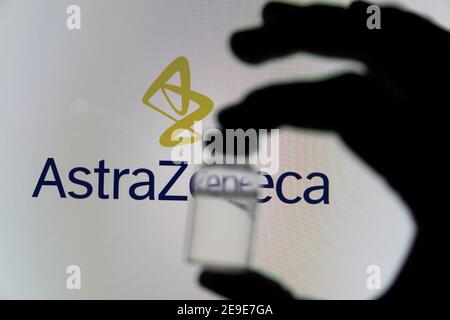 OXFORD, Großbritannien - Februar 2020: Covid-Impffläschchen vor dem AstraZeneca-Logo Stockfoto