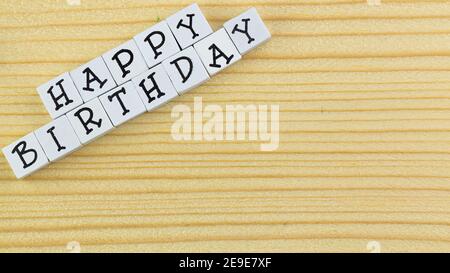 Der Text 'Happy Birthday', der aus den Blöcken auf hölzern angeordnet ist Hintergrund Stockfoto