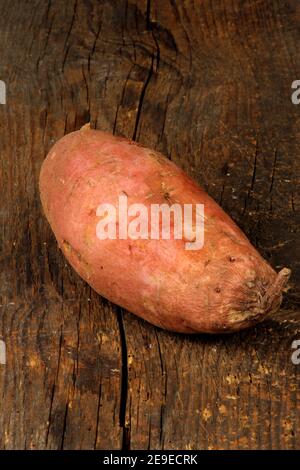 Rohe Süßkartoffeln oder Batatas auf altem Holzbrett. Batatas auf hölzerner Oberfläche Stockfoto