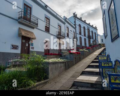 Firgas, Gran Canaria, Kanarische Inseln, Spanien 13. Dezember 2020: Blick auf die Straße Paseo de Gran Canaria mit Wasserfall Brunnen, Blumen und Keramik Stockfoto