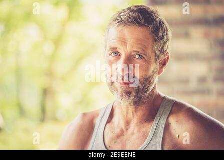 Porträt von müde bärtigen Mann mit Schweiß auf seinem Gesicht nach harter Arbeit in der Gartenarbeit. Warmfilter Retro. Stockfoto