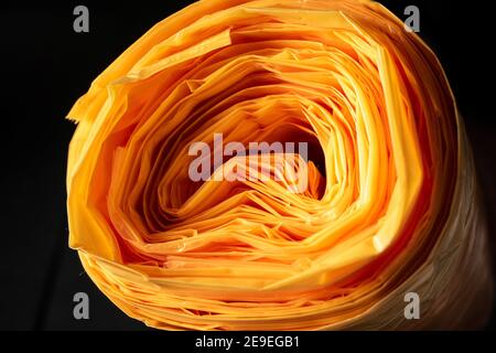 Eine Rolle oranger Plastiktüten als Nahaufnahme mit vielen Schichten. Stockfoto