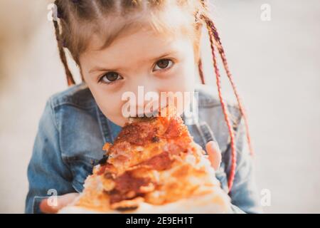 Kinder essen Pizza. Fastfood für Kinder. Junkfood-sucht. Italienische Küche. Kinderessen. Adipositas im Kindesalter. Leckeres Essen für Kinder. Stockfoto