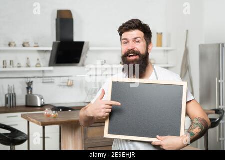 Kreidetafel für Werbung. Brutal Hipster Mann hält leere Tafel, Kopie Raum. Jobsuche. Es gibt Stellenangebote. Shopping Verkauf und Rabatte. Chef-Menü in der Küche. Schauen Sie dort vorbei. Stockfoto