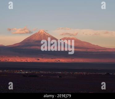 Faszinierende Aussicht auf die hohen Berge mit den Gipfeln bedeckt Im Schnee, der unter dem Sonnenuntergang glänzt Stockfoto