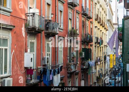 Neapel, Italien - 6. September 2019: Fassade von klassischen Gebäuden mit hängenden Kleidung und Frauen auf dem Balkon im historischen Zentrum von Neapel, Italien Stockfoto