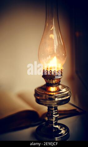 Vintage Kerosin Lampe brennend und alte offene Buch Stockfoto